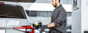 A stock photo of a person putting gas in their car.